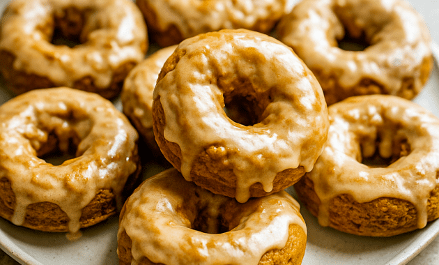 Golden Baked Donuts made with pumpkin, topped with shiny maple Donut Glaze—a cozy Homemade Donuts Recipe perfect for Fall Baking Recipes, Pumpkin Dessert lovers, and anyone looking for festive Herbst Rezepte or sweet Pumpkin Recipes Dessert ideas.