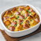 Eggs Benedict casserole in a baking dish with golden muffin cubes, Canadian bacon, and hollandaise sauce — a Best Easy Breakfast Casserole that works as a Summer Brunch Dish, Breakfast For Dinner For A Crowd, or thoughtful Food For A Wake. Perfect Shareable Breakfast Dishes, easy Egg Bake Ideas, and versatile Make Ahead Brunch Dishes for holidays, gatherings, or casual Brunch Ideas For Two People.