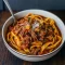 A bowl of pasta topped with rich Beef Ragu Recipe from a slow cooker, garnished with Parmesan and parsley, showcasing a comforting Slow Cooker Dinner perfect for hearty meals.