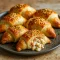 Golden brown Crab Filled Crescent Rolls on a parchment-lined tray, with creamy crab and cheese peeking out, sprinkled with fresh parsley – the perfect easy appetizer for parties and quick Crab Meals.