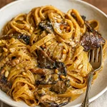Bowl of creamy pasta with caramelized Leeks, mushrooms, and gruyère, topped with toasted pine nuts. A rich and comforting dish for cozy nights, perfect for Vegetarian Dishes, easy Veggie Recipes, and classic Pasta Dinner Recipes like Mac And Cheese, Tortellini, and even lighter meals such as Salad Pasta. A flavorful option for fans of Mushroom Recipes and Receitas Vegetarianas.