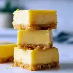 Close-up of creamy Lemon Squares with golden graham cracker crust and smooth lemon filling, dusted lightly for a bright, tangy Sweet Bar dessert.