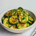 Sliced cucumbers tossed in creamy spicy peanut sauce, topped with toasted peanuts and fresh herbs.