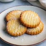 Stack of golden, flaky French salted butter cookies dusted with sea salt on parchment — a gorgeous French Salted Butter Cookies shot that works for Bar Cookies, showcases a Unique Cookie Recipes idea, and inspires Cookie Exchange Recipes; perfect for fans of French Cookies, home Cooking Cookies, and easy Cookie Recipes Homemade—a lovely Butter Cookies Recipe with How Sweet Eats charm.