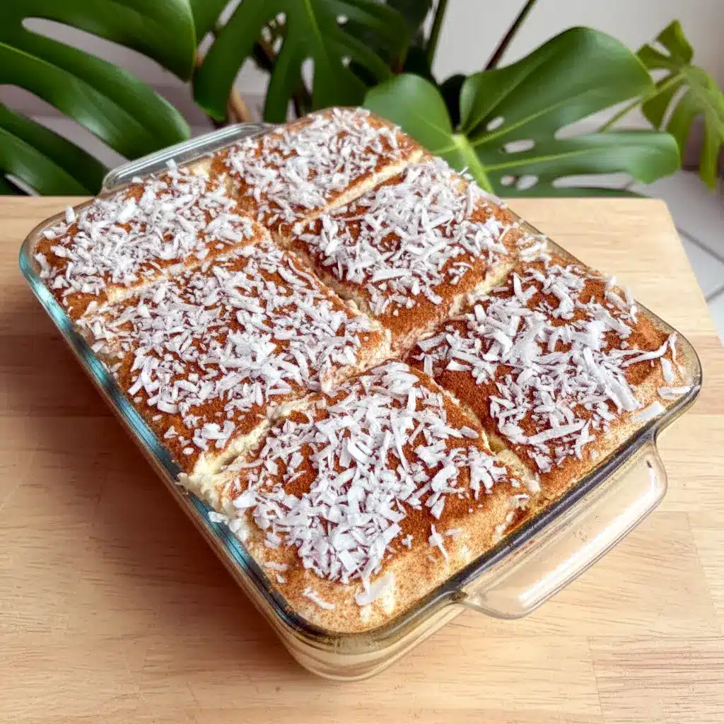 Tiramisu Recipe — close-up of a coconut-rum tiramisu slice showing creamy mascarpone layers, toasted coconut flakes, and a cinnamon dusting.