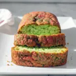 A golden-green loaf of Pistachio Bread topped with sprinkles, sliced on a holiday table—an easy, festive Holiday Bread perfect for gifting and celebrating.