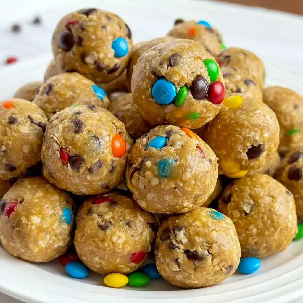 The Best Energy Balls stacked on parchment with visible mini chocolate chips and colorful M&Ms — a tempting Monster Cookie snack.