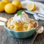 Close-up of a golden lemon cobbler bubbling with syrup, topped with a dollop of ice cream — a tempting Lemon Curd Dessert Recipes idea, almost like a silky Lemon Bisque Dessert, listed among quick Cobblers Recipes and classic Lemon Cobbler Recipes.