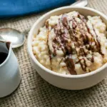 Close-up of a warm bowl of eggnog rice pudding with chocolate drizzle — perfect for Pudding Recipes (not icy Slushies), Holiday Eggnog Rice Pudding.