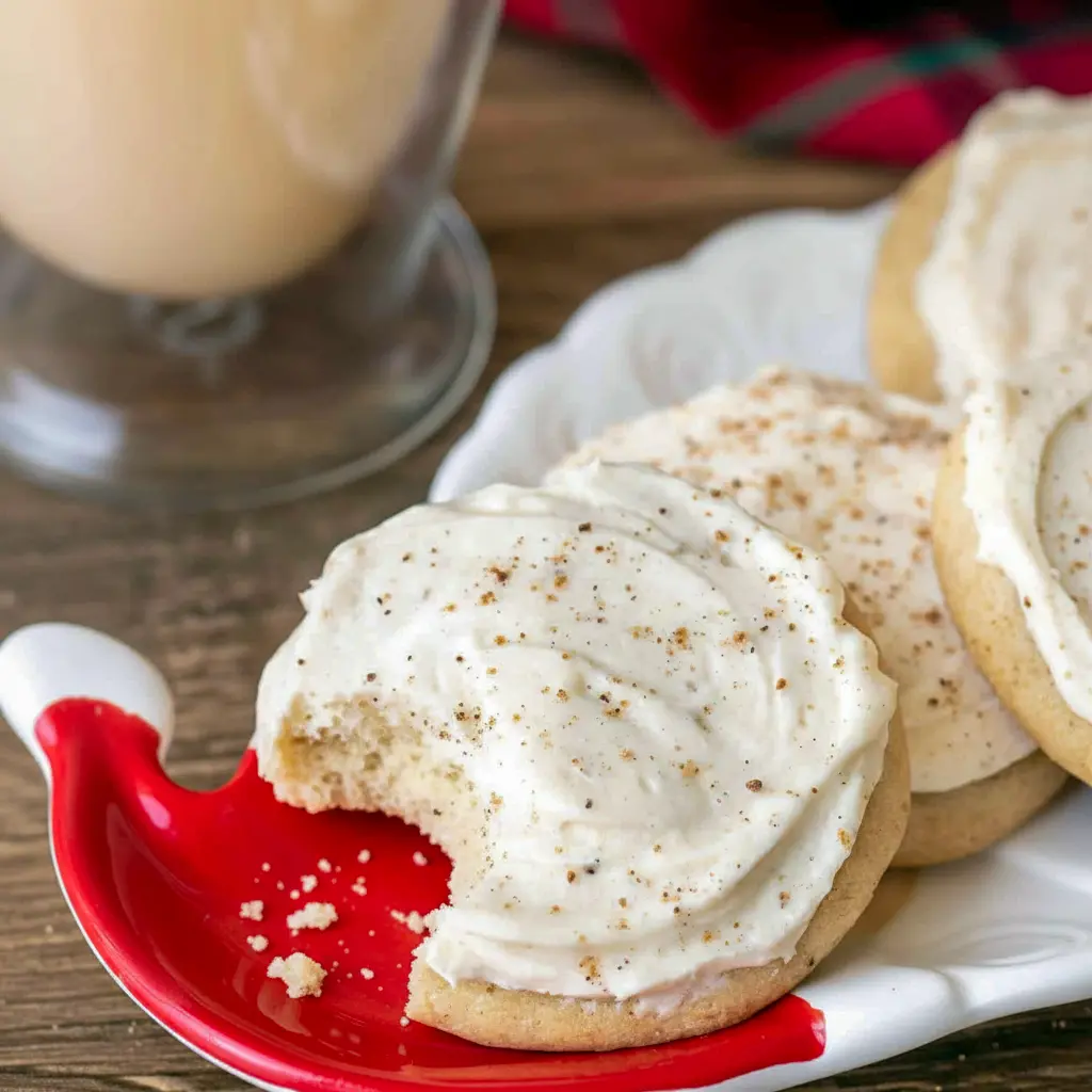 Close-up of frosted cookies showing nutmeg dusting and creamy swirl — Gooey Christmas Cookies that are surprisingly Eggnog Cookies Easy to make, topped with rich Eggnog Frosting, and adaptable as Gluten Free Eggnog Cookies, Eggnog Christmas Cookies.