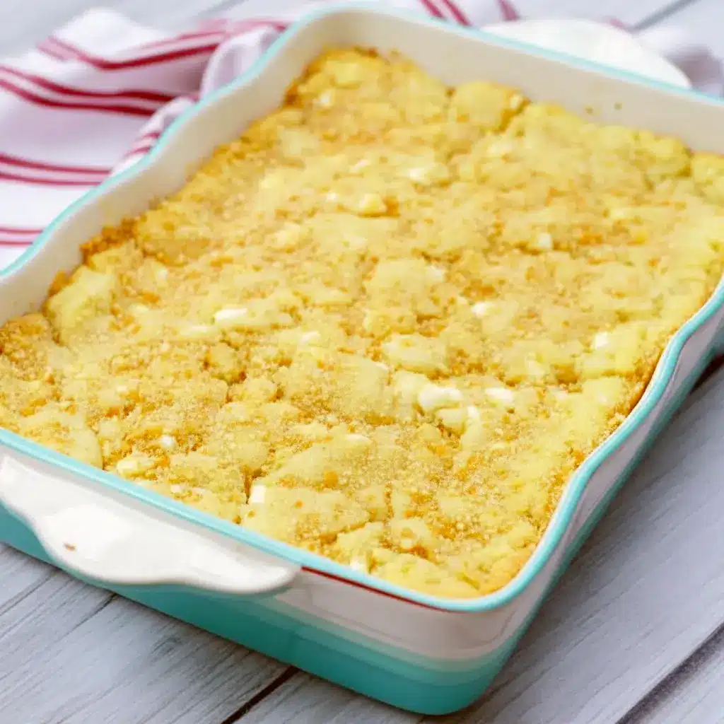 Close-up of a gooey Banana Blondies Recipe square on parchment, showing a golden vanilla-wafer crust, white chocolate pockets, and a fork ready to dig in.