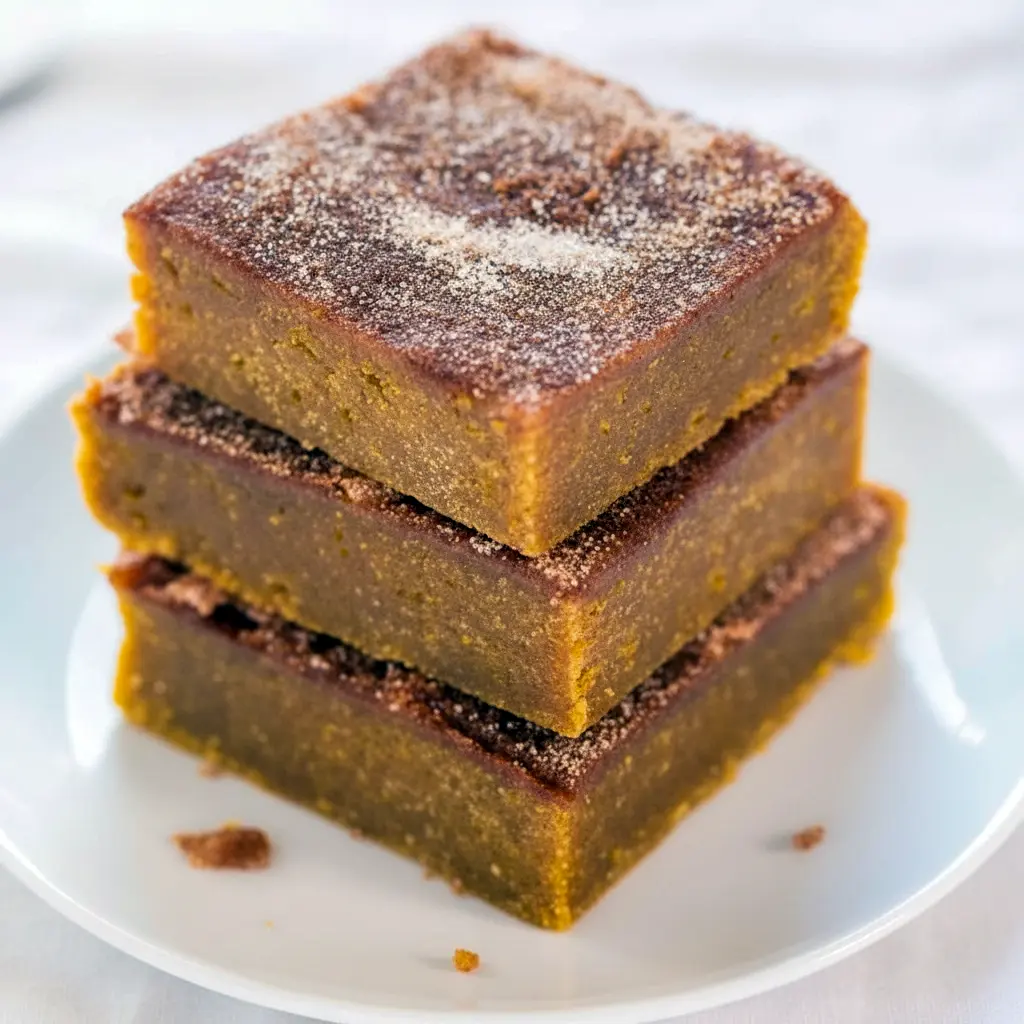 Snickerdoodle Blondies Recipe squares on a wooden board, cinnamon-sugar crust and pumpkin-hued interior visible, styled for a cozy Thanksgiving Desserts spread.