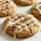 Coffee Cake Cookies on a wire rack: golden, streusel-topped cookies with a glossy icing drizzle, styled beside a steaming mug of coffee.