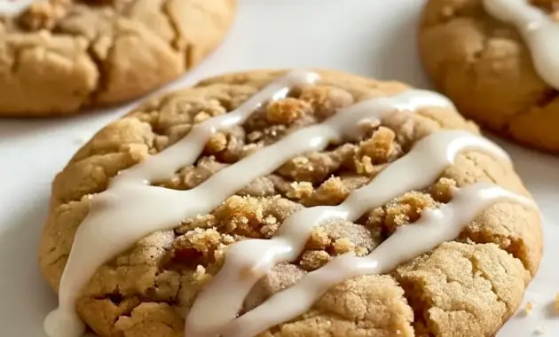 Coffee Cake Cookies on a wire rack: golden, streusel-topped cookies with a glossy icing drizzle, styled beside a steaming mug of coffee.