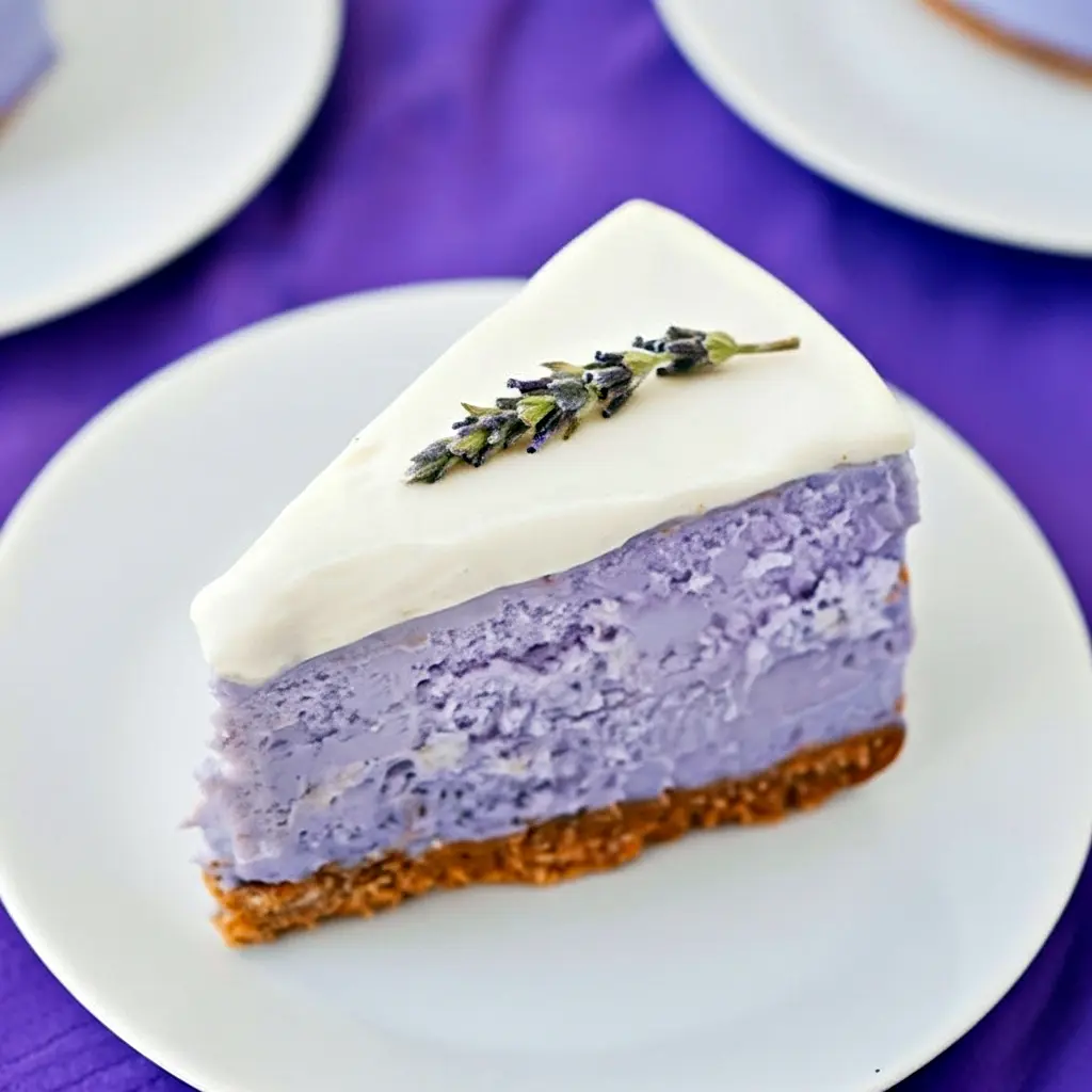 A slice of pale-violet cheesecake drizzled with honey and garnished with basil — a gorgeous Lavender Cheesecake Recipe photo that highlights Recipes Using Creamed Honey, pairs nicely with light Lavender Savory Recipes, and belongs in any Baking Recipes Lavender collection, Honey Lavender Cheesecake.