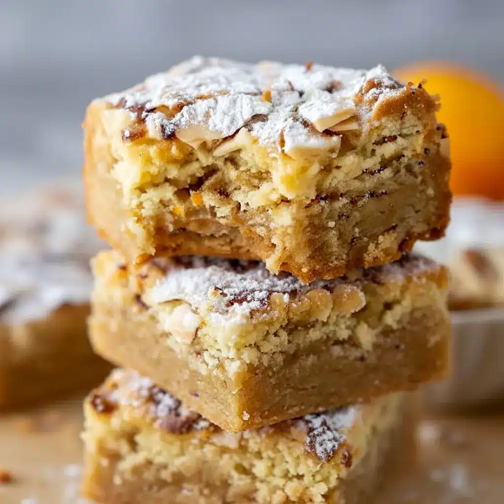 Close-up of golden blondie squares with swirled almond frangipane, toasted sliced almonds, and a light dusting of powdered sugar, Almond Croissant.