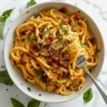 Glossy spaghetti coated in a creamy egg-and-cheese sauce with visible kimchi pieces, crispy bacon bits, grated Parmesan, and sliced scallions on top, Carbonara Recipe.