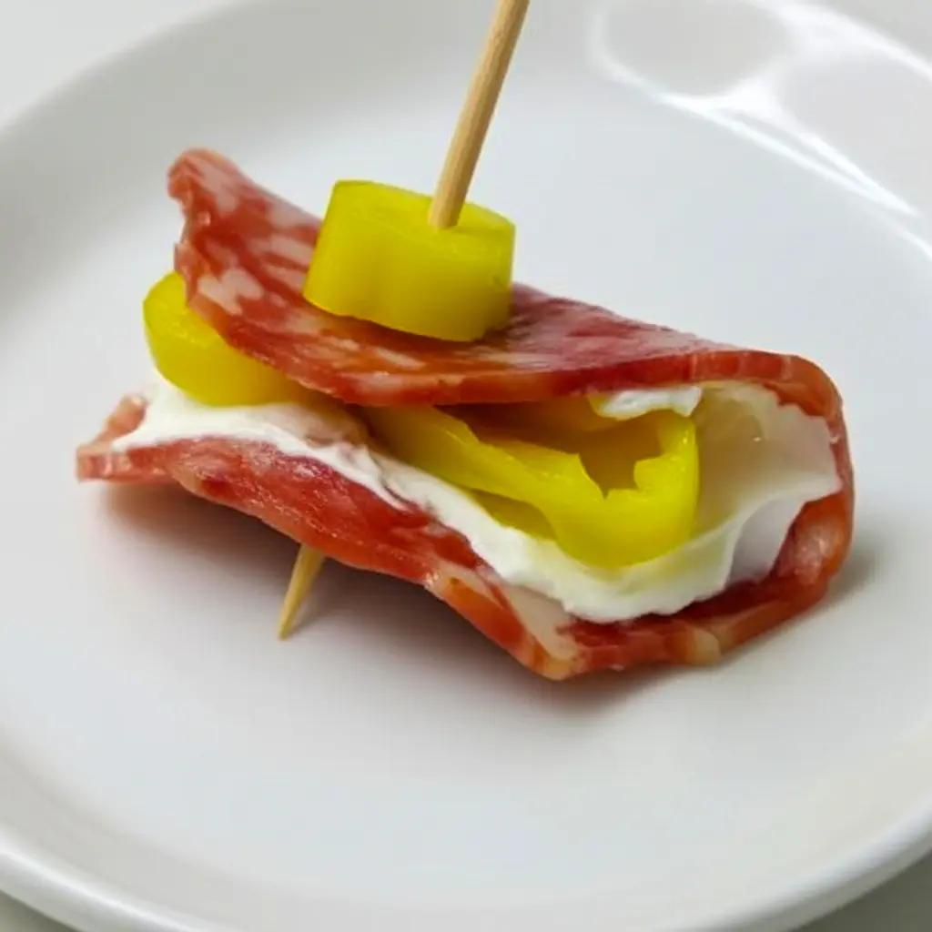 Platter of Salami Cream Cheese Pepperoncini Roll Ups arranged on a board, showing creamy centers and tangy pepperoncini — ideal Finger Food Appetizers for a crowd.