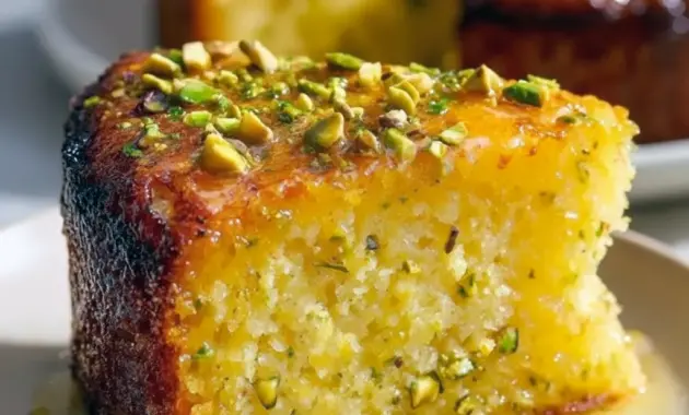 A slice of Lemon Pistachio Cake with lemon glaze and chopped pistachios — an easy Gluten Free Cake Almond Flour Recipe.