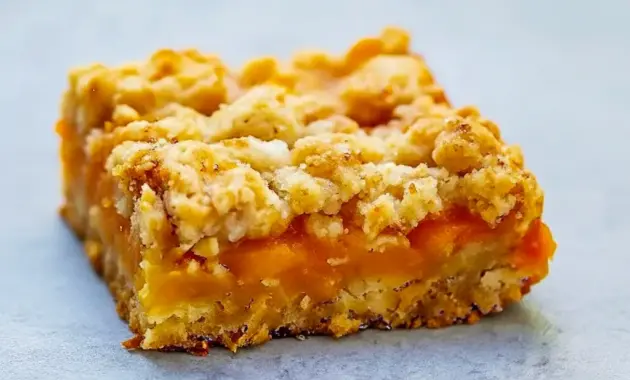 Mango Oatmeal Bars — golden oat crumble bars with bright mango filling stacked on a wire rack, ready to serve.