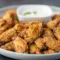 Close-up of crispy Dill Pickle Chicken Wings glazed with dill and served with a bowl of creamy Pickle Wing Sauce — a tangy Pickle Juice Wings favorite.
