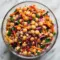 Bowl of Asian Chickpea Salad with shredded red cabbage, diced bell pepper, chickpeas, chopped peanuts, and a creamy tahini-lime dressing.