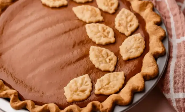 Slice of Apple Butter Pie on a plate with a dollop of maple whipped cream, showing creamy filling and a golden crust — a classic Fall Baking and Holiday Desserts favorite.