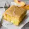 Brown Sugar Peach Cake in a 9x13 pan with tender yellow cake, fresh peach pieces, and a glossy brown sugar frosting on top.