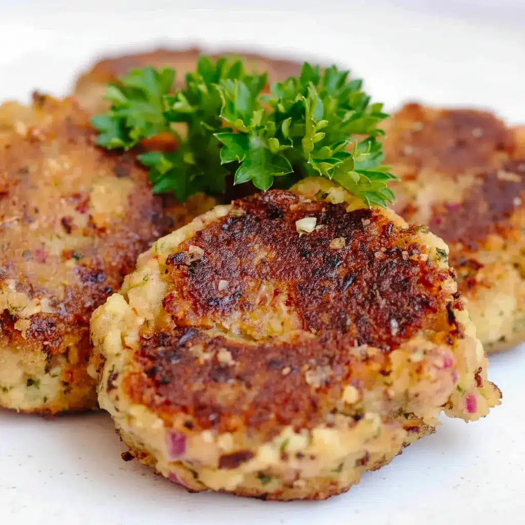 Close-up of golden Easy Falafel Recipe patties on a plate with pita, a bowl of tzatziki, and fresh parsley garnish.