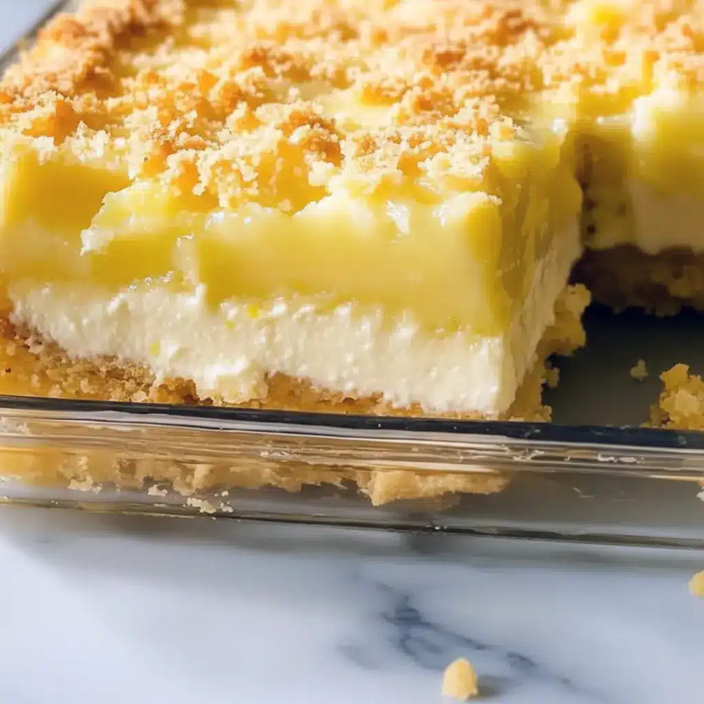 Lemon Cream Cheese Dump Cake — slice of golden crumb-topped cake showing bright lemon filling and a creamy layer, plated with a dollop of whipped cream.