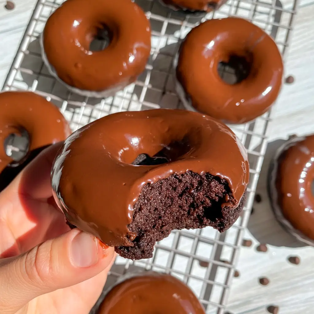 Chocolate Protein Donuts — six chocolate-glazed donuts on a wire rack, showing moist interior and glossy dark-chocolate finish, paleo and gluten-free.