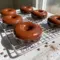 Chocolate Protein Donuts — six chocolate-glazed donuts on a wire rack, showing moist interior and glossy dark-chocolate finish, paleo and gluten-free.