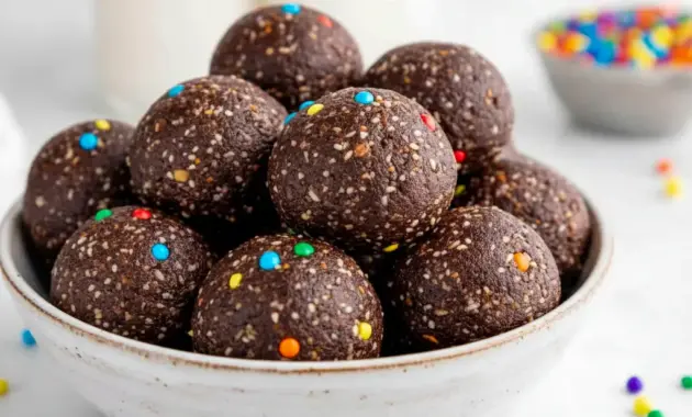 A plate of Cosmic Brownie Bites with a fudgy chocolate texture and rainbow candy-coated chips, styled as a healthy No Bake Dessert Bites treat.