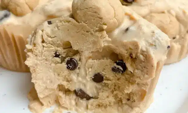 Close-up of three Cookie Dough Cups in paper liners: creamy yogurt base, little protein cookie-dough bites, and chocolate chips on top.