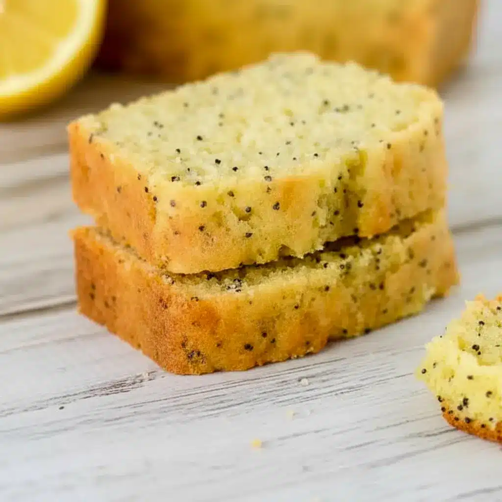 A sliced loaf of Lemon Poppy Seed Zucchini Bread with a soft golden crumb and visible poppy seeds, styled as a fresh Lemon Poppy Seed Dessert for Spring Baking Ideas.
