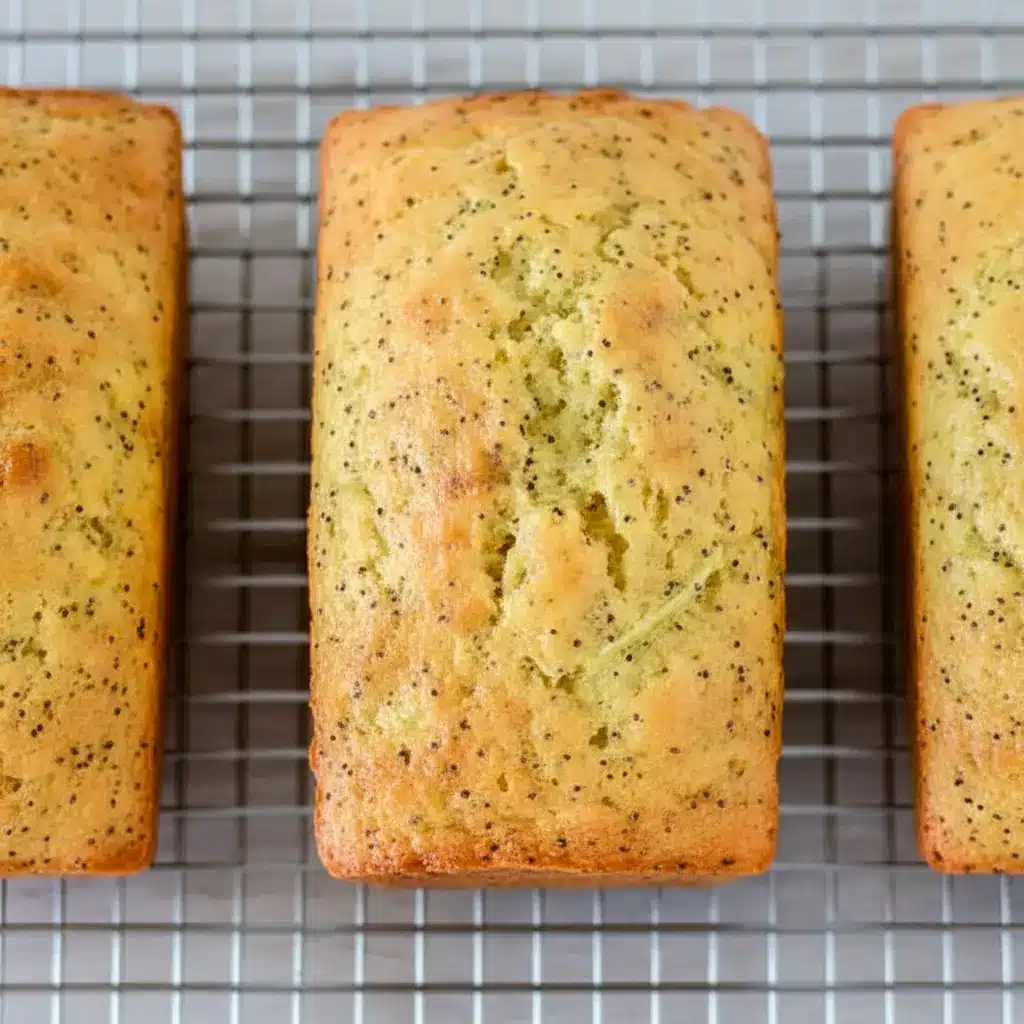 A sliced loaf of Lemon Poppy Seed Zucchini Bread with a soft golden crumb and visible poppy seeds, styled as a fresh Lemon Poppy Seed Dessert for Spring Baking Ideas.