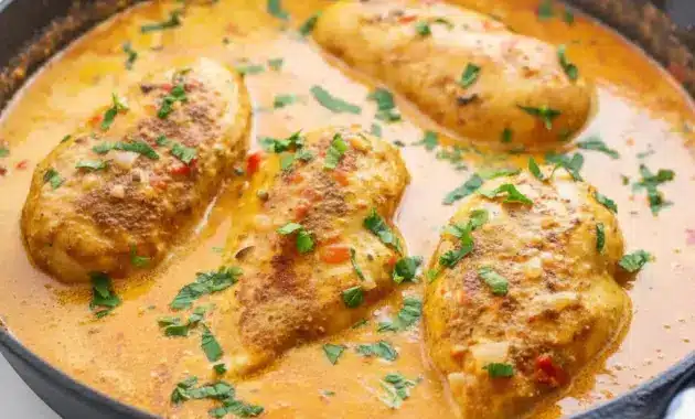 Close-up of Spicy Brazilian Coconut Chicken in creamy coconut-chili sauce with lime and cilantro, served over steamed rice.