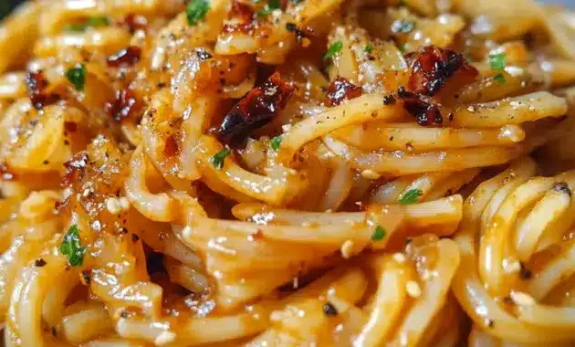 Close-up of glossy Caramelized Onion Pasta tossed with jammy onions, chili oil sheen, and grated Parmesan — a rustic Pasta Dishes favorite.