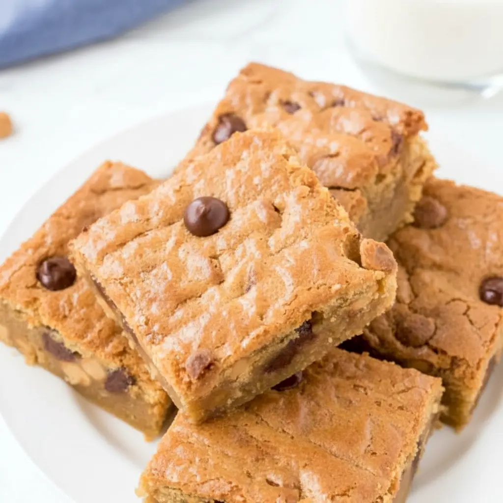 Freshly baked Peanut Butter Blondies in a pan, styled like a rich Peanut Butter Blondie Bar Recipe with golden tops, candy pieces, and melty chocolate chips.