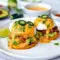 Mexican Eggs Benedict on sweet potato rounds with avocado, chorizo, and chipotle hollandaise for an Eggs Benedict Alternative that feels bold and brunch-worthy.