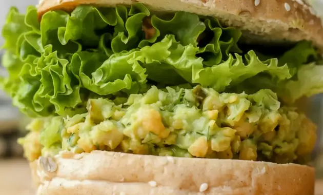 Smashed Chickpea Avocado Dill Pickle Sandwiches on whole grain bread with crisp lettuce and Avocado Chickpea Salad Sandwich filling for an easy healthy lunch.