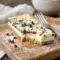 Cannoli Cheesecake Bars served chilled on a plate, a creamy Cannoli Desserts favorite with chocolate chips.