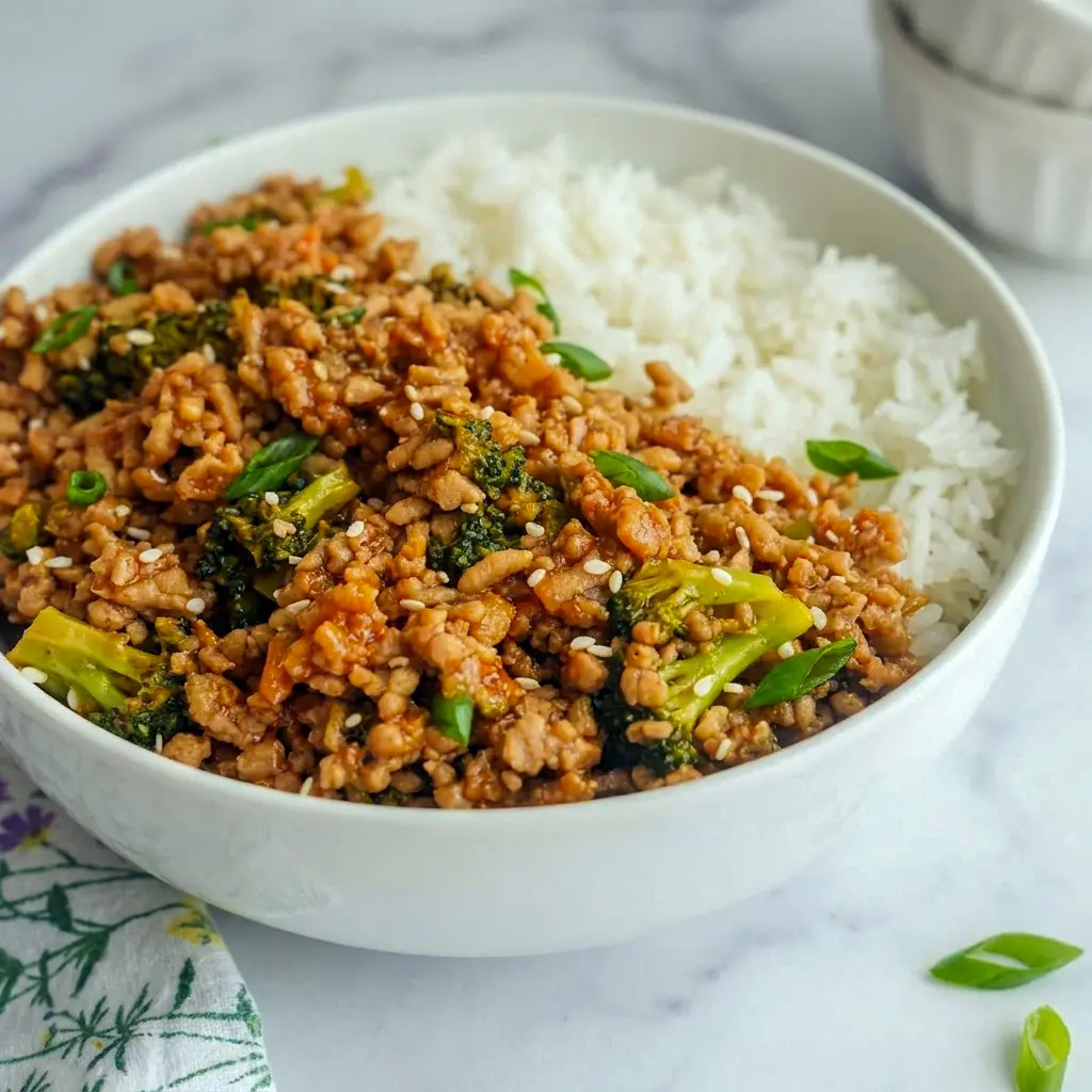 A close-up of Firecracker Ground Chicken Bowl made for Healthy Dinner Recipes Ground Chicken and topped with green onions and sesame seeds.