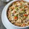 Chicken and Wild Rice Hotdish That’ll Warm You Right Up2 Golden, bubbly Chicken Wild Rice Hotdish baked in a casserole dish, topped with crispy breadcrumbs and melted cheese, surrounded by fresh herbs and a serving spoon ready to dig in.