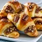 Golden, glossy Pecan Pie Crescent Rolls on a tray made with Crescent Roll Dough (or Homemade Dough), chopped pecans on top and flaky, buttery Flaky Pastry visible in each roll.