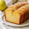 Golden apple cider cinnamon bread loaf with a crackly cinnamon sugar topping, sliced on a wooden board with apples and cinnamon sticks around it.