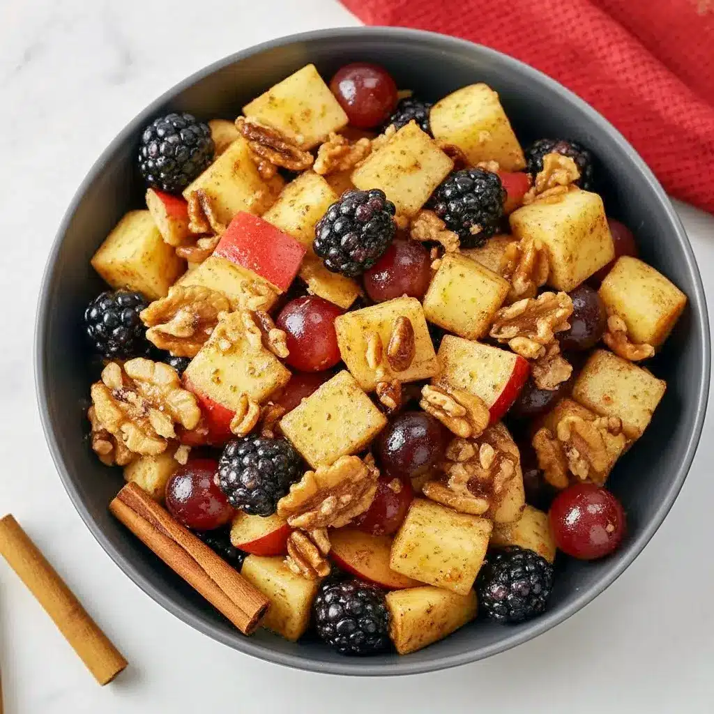 Overhead bowl of fall fruit salad with apple cubes, red grapes, blackberries and pecans, glazed in an orange-cinnamon dressing, Fall Fruits.