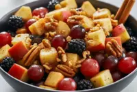 Fall Fruits Salad with Orange Cinnamon Dressing — Cozy, Spiced And Simple Overhead bowl of fall fruit salad with apple cubes, red grapes, blackberries and pecans, glazed in an orange-cinnamon dressing.