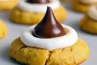 Close-up of golden brown Hershey's Kiss Cookies topped with toasted marshmallows and melted chocolate kisses, the perfect homemade Kiss Cookies for holidays or dessert platters.