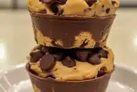 Close-up of golden peanut butter chocolate chip cookie cups cooling in a muffin tin — a tempting shot for Unique Dessert Recipes Baking boards, Unique Desert Ideas, and lists of Things To Make With Cookie Dough (yes, even cheeky roundups like Desserts That Go With Fish for adventurous menus).